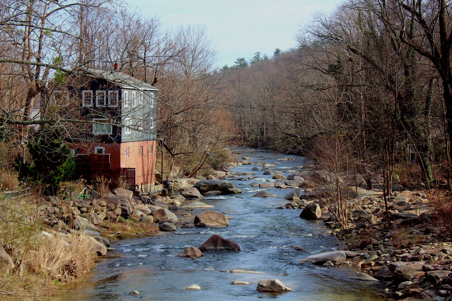 Rocky river flowing behind a blue house