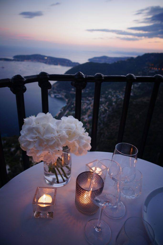 two clear wine glass beside tealight candle on table couples' getaways