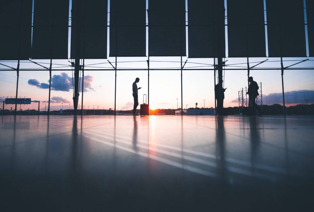 people waiting at an airport near sunrise. holiday travel