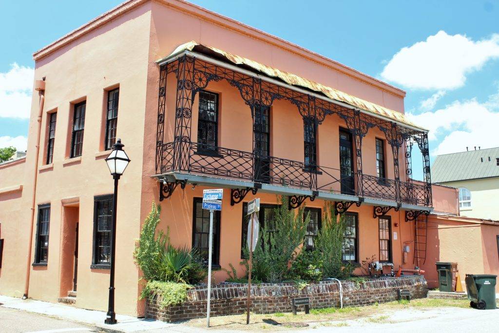 Ornate pink building with iron balconies in Charleston's French Quarter