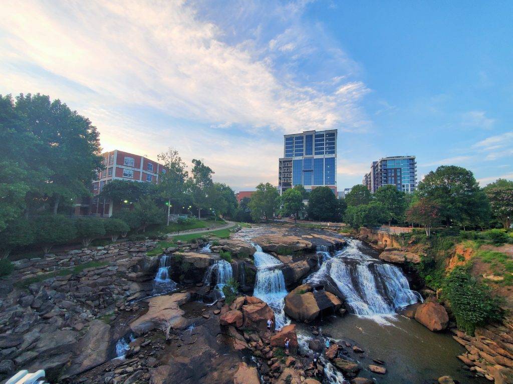 Large waterfalls with a backdrop of a city scene in Greenville