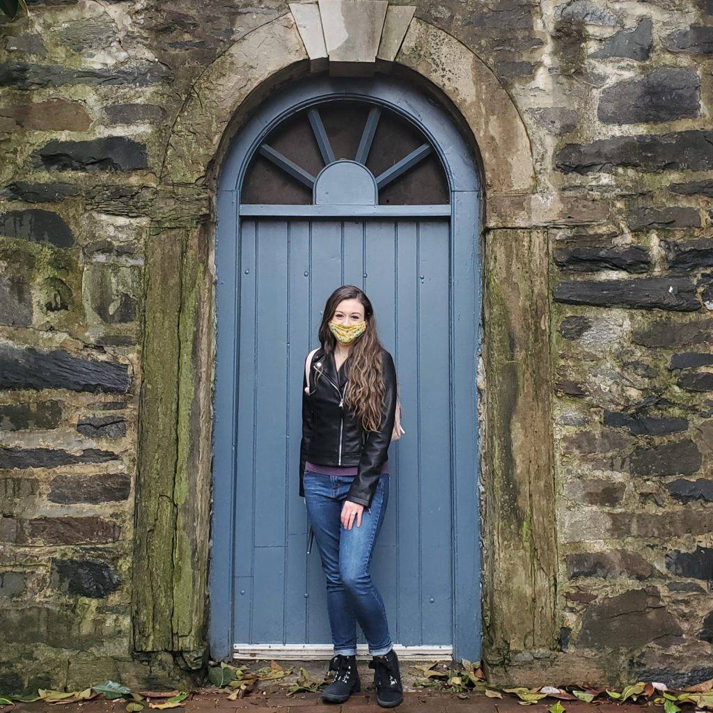 blue door set into a mossy stone wall