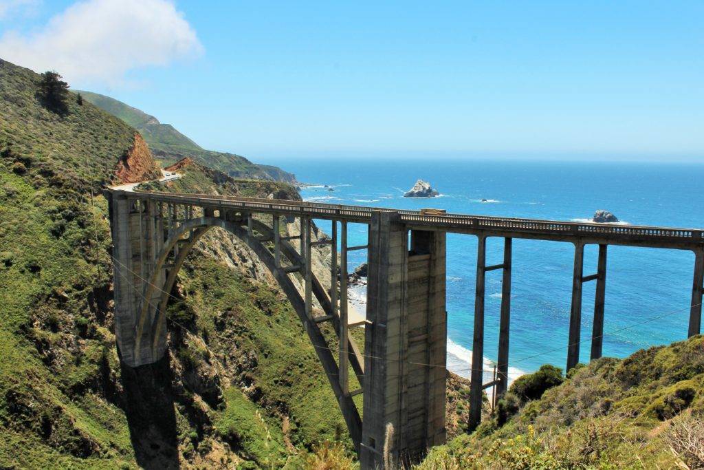 Bixby Bridge spanning the valley with the Pacific Ocean in the background. Highway 1
