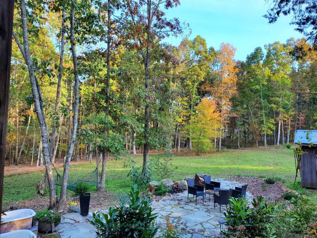 Large green yard with two iron tubs and a seating area and hammock HeartRock Homestead