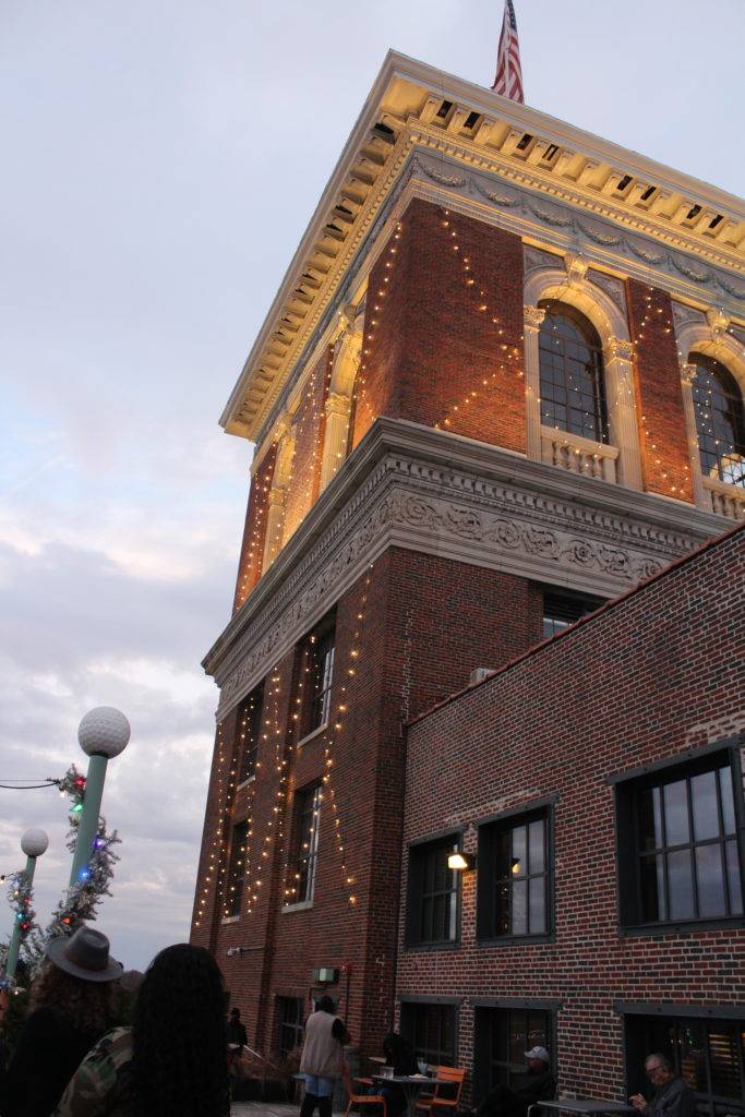 brick tower strung in lights with artistic moulding around the lower level. ponce city market the ROOF