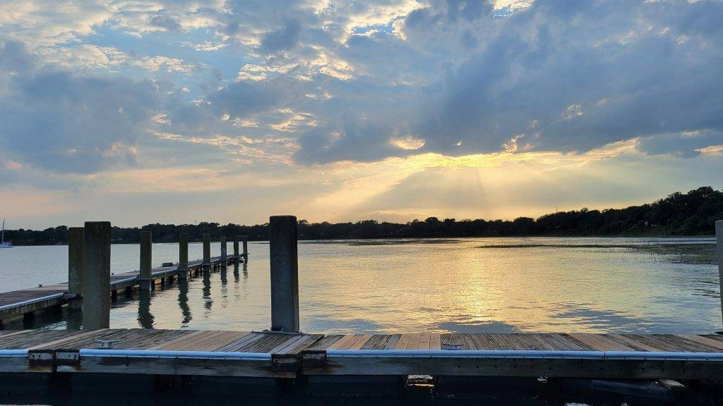 sun setting over water with a pier in the foreground. waterfront park beaufort, sc