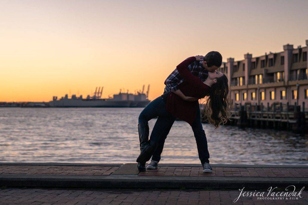 couples kissing on a dock with a battleship in the background at sunset. norfolk, va