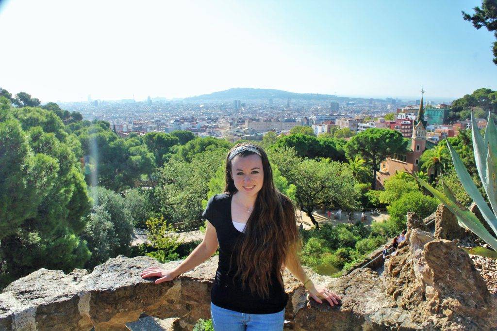 Girl standing on a balcony with Barcelona off in the distance