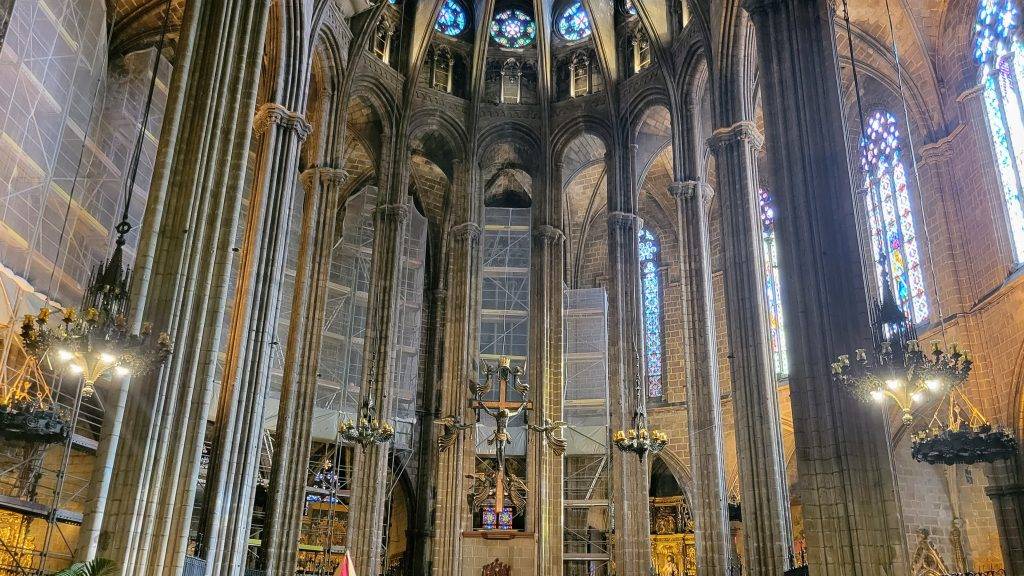 a Catholic Cathedral with stone pillars and a statue of Jesus hanging on the cross