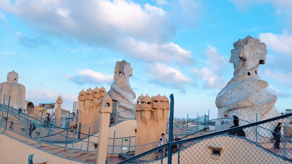 Gaudi's stone warriors at Casa Mila against a blue sky with clouds