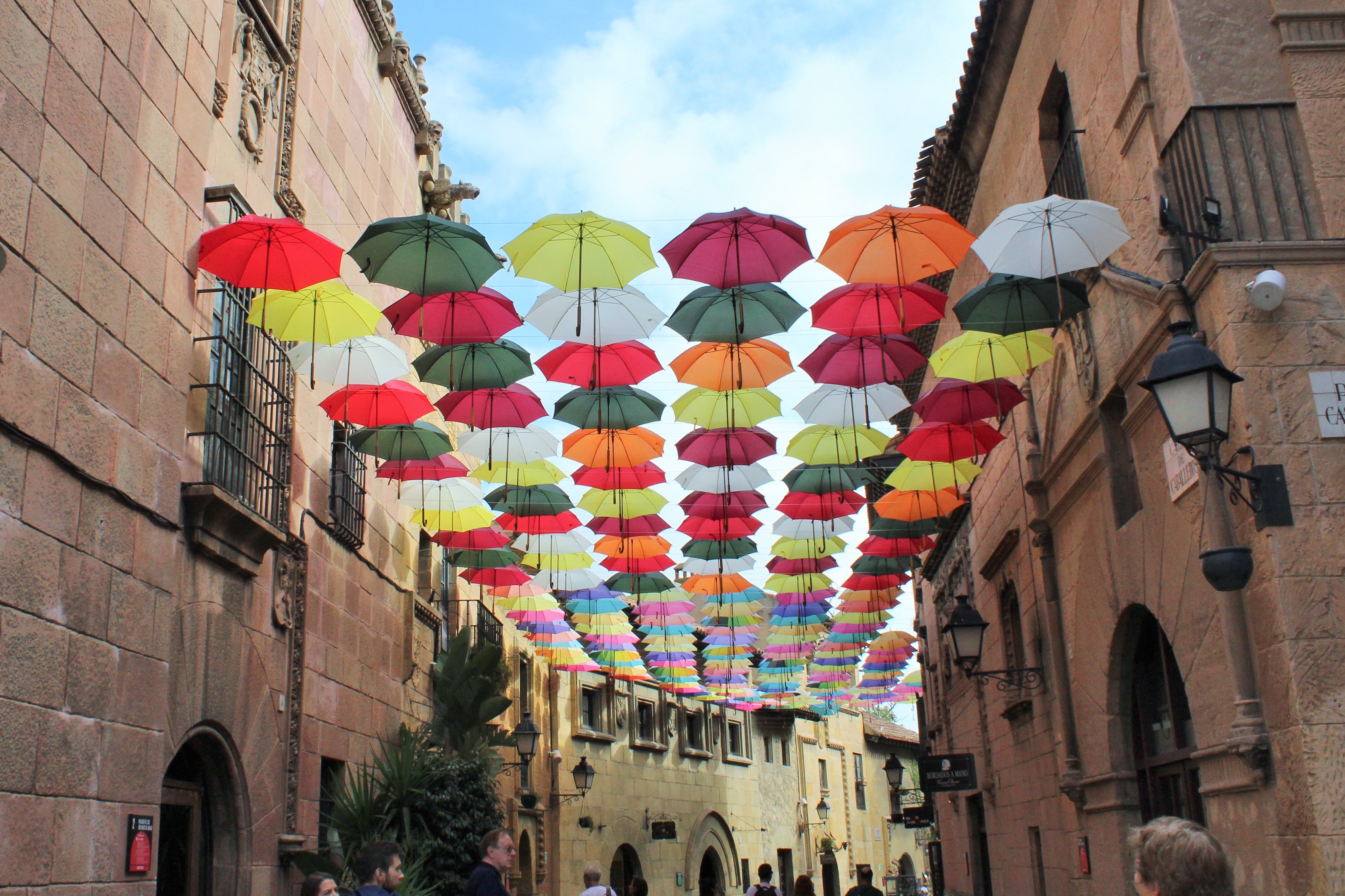 Colorful umbrellas hanging above a street in Poble Espanyol