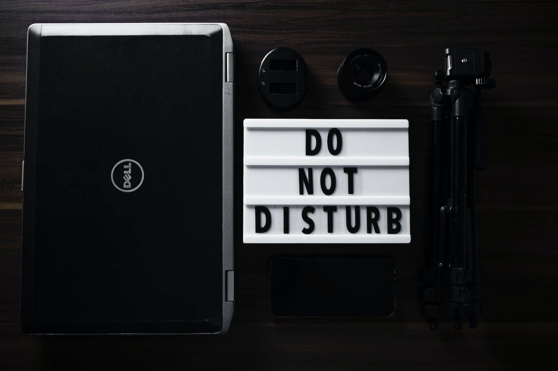 overhead shot of a lighted letter board beside a laptop