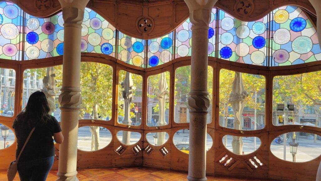 Front window of Casa Batllo with colorful circles and odd-shaped panels