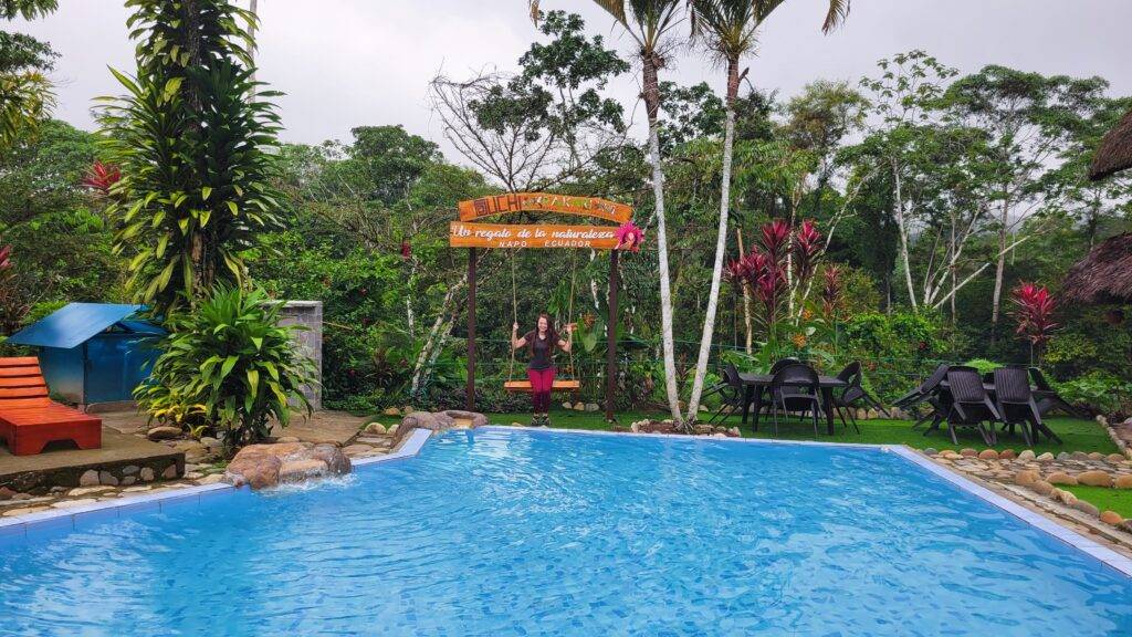 Girl in a swing by a pool with a Suchipakari sign