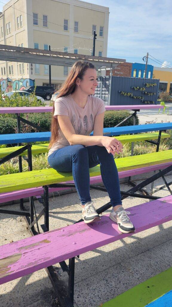 Girl on a colorful bench wearing Taos sneakers