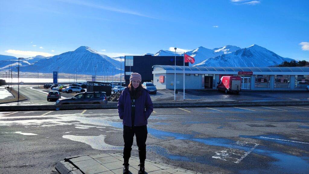 Girl standing in front of mountains in a parking lot at Borgarnes, Iceland