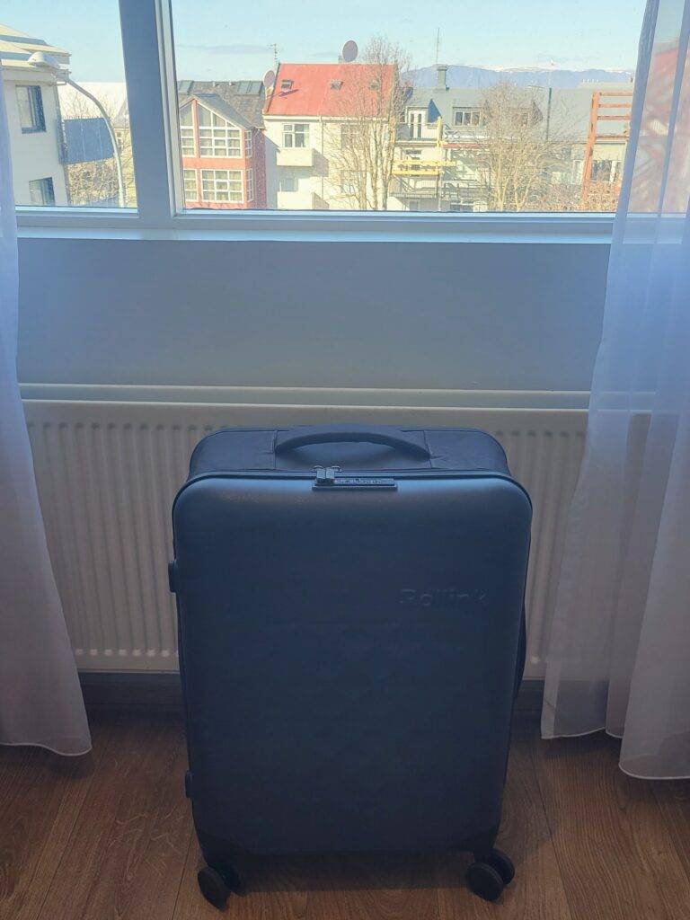 Rollink suitcase under a hotel window