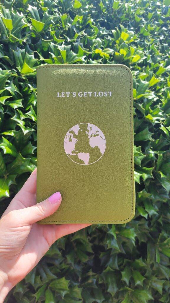 Phone-Charging passport wallet with holly in the background