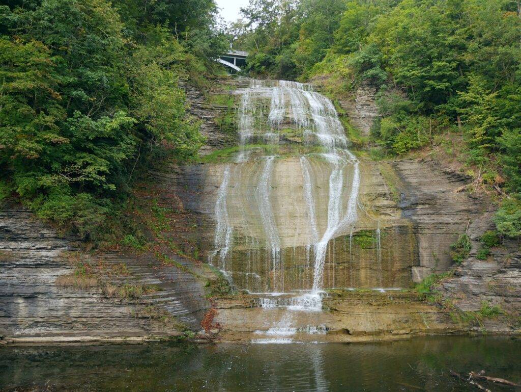 Tiered waterfall flowing underneath a bridge
