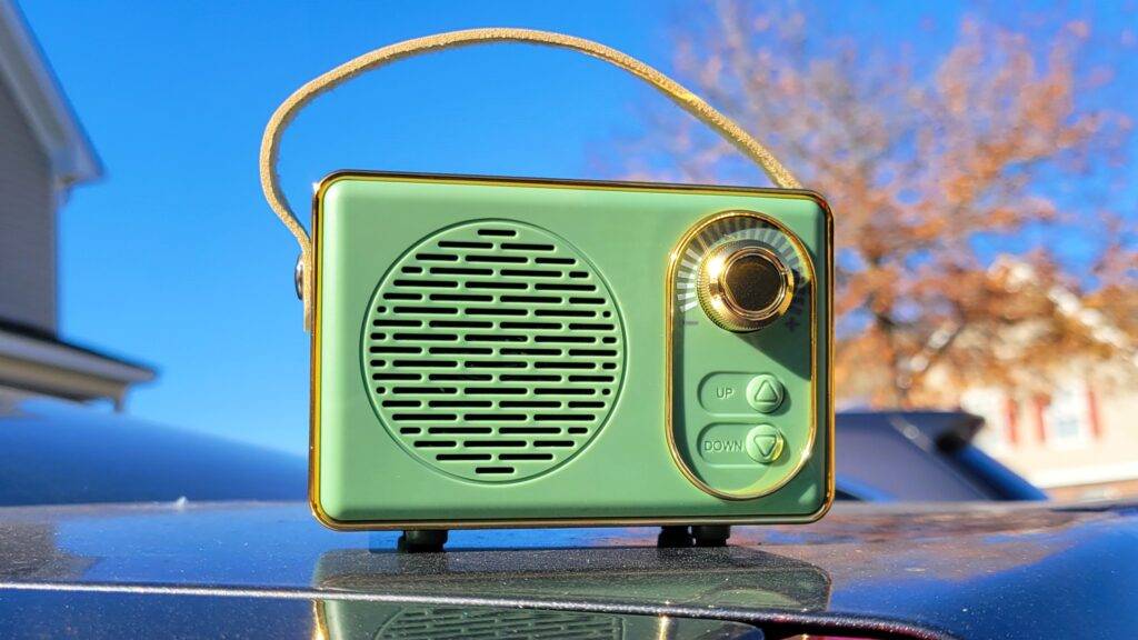 portable retro radio speaker with a blue sky and tree in the background