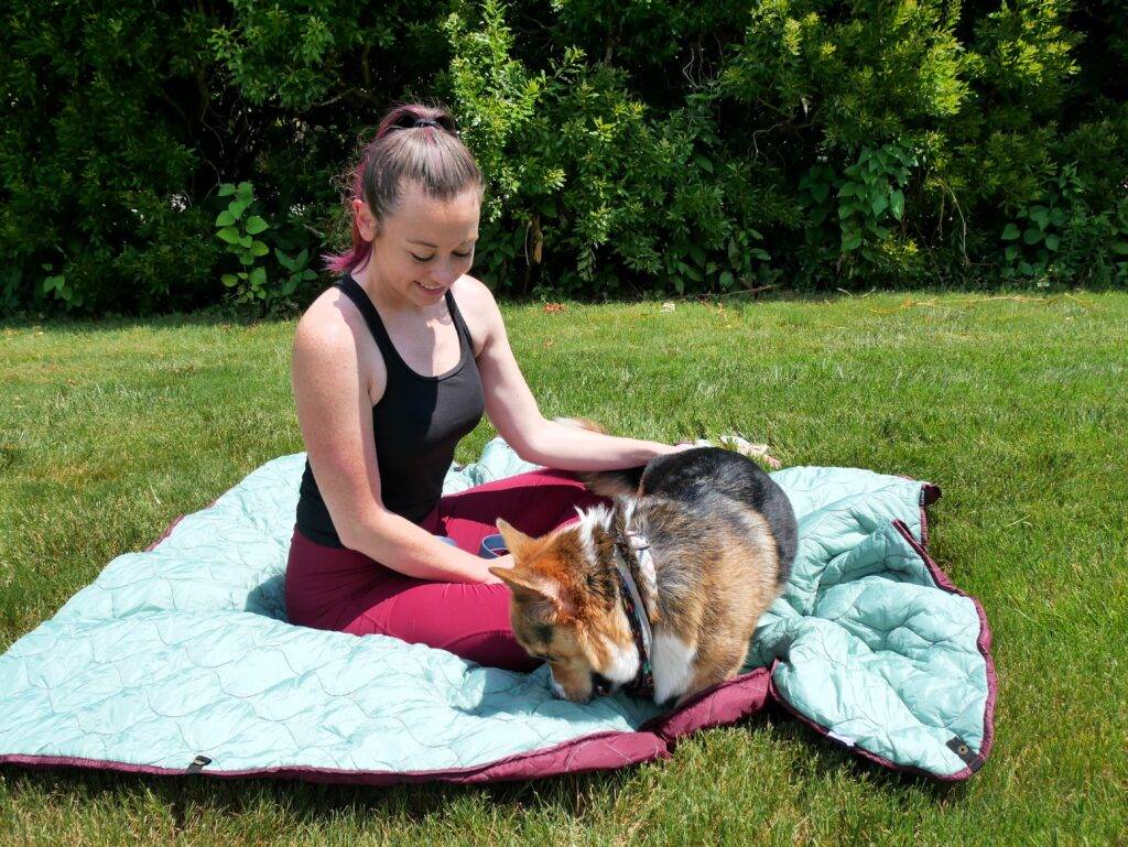 Girl with dog on Coalatree Puffy Kachula Blanket, travel accessories