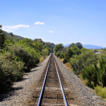 train tracks going off into the distance with mountains in the background on the Virginia Scenic Railway